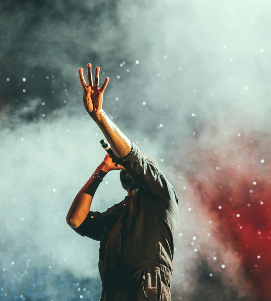 Artist performing on stage through red smoke